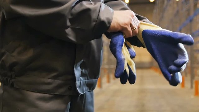 Slow Motion Closeup Worker Puts on Gloves in Warehouse
