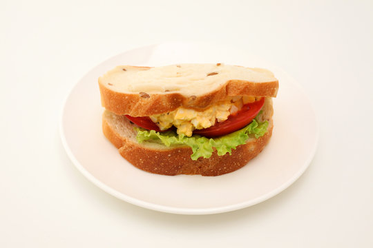 お皿にのせた エッグレタストマトサンド パン サンドウィッチ 白背景