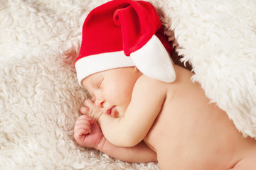 A baby in a Santa Claus hat