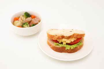 お皿にのせた エッグレタストマトサンド パン サンドウィッチ  ポトフ スープ 白背景
