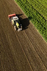 Fotobehang aerial view of the tractor on the harvest field © mariusz szczygieł