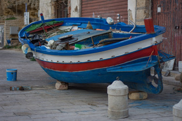 Fototapeta na wymiar Barca da pesca su marciapiede, Sicilia