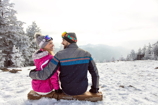 Couple in love sitting on ski terrain