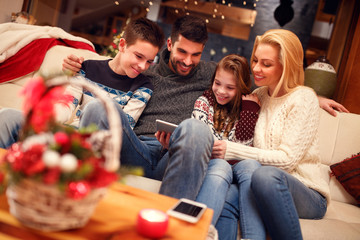 Family using digital tablet on Christmas holidays.