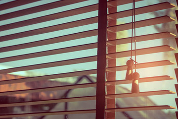 Close up open sunshade or curtain with ray of sunlight through from the window in vintage style. (Soft focus)