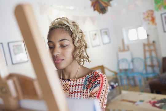 Young woman standing in front of an easel