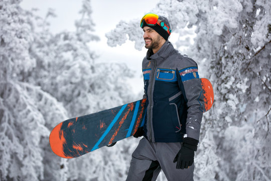 man with ski mask holding his snowboard, extreme sport and winter holiday