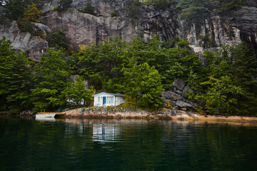 Fototapeta na wymiar A lonely house on the shore in a Norwegian fjord