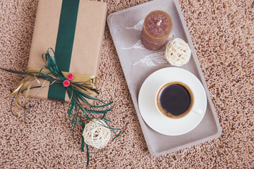Brown carpet, packing with gift and a cup of coffee