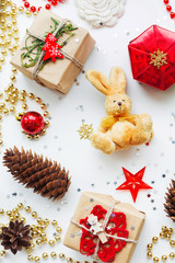 Christmas and New Year background with decorations. Gifts in craft paper, pine cones, red hearts and confetti. Flay lay, top view.