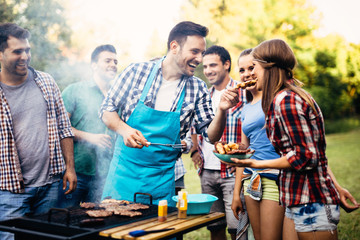 Happy friends enjoying barbecue party - obrazy, fototapety, plakaty