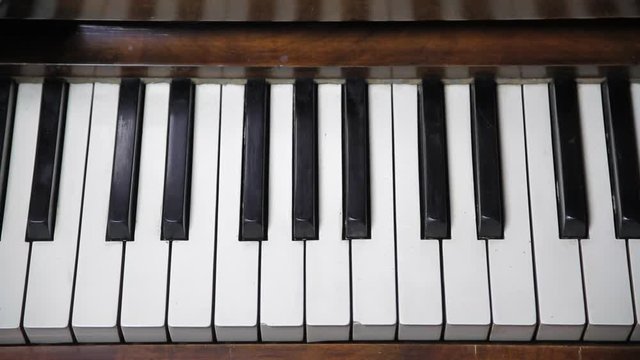 Slow overhead tracking shot of old piano keyboard