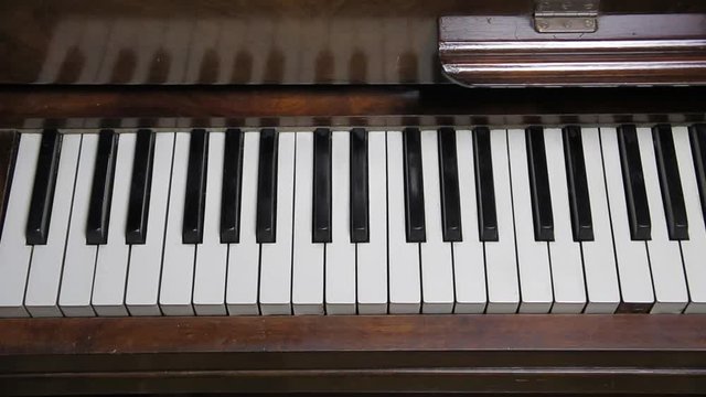 Slow overhead tracking shot of old piano keyboard 