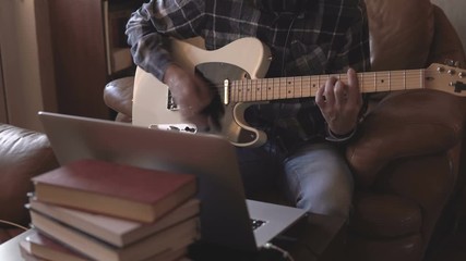 Home recording musician series. A young guy improvising on the guitar - Powered by Adobe