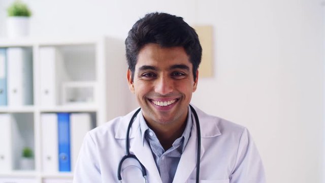 portrait of happy smiling young indian male doctor