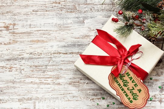 Xmas gift box with Tag on festive white wooden background / Christmas Holiday Concept ,Top down view