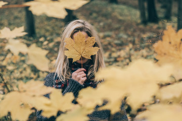Woman hiding behind big leaf