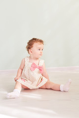 little girl is sitting in the studio and is playing