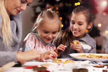 Obraz premium Joyful family preparing Christmas biscuits