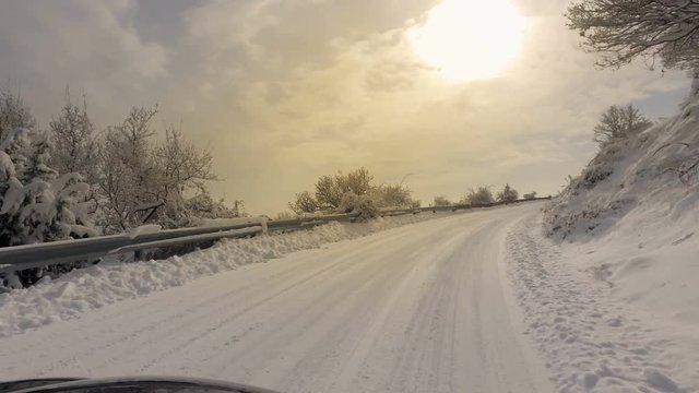 Car and falling snow in winter on forest road with much snow