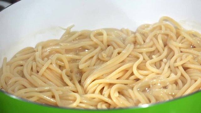 Boiling spaghetti in pan on electric stove in the kitchen, LOOP