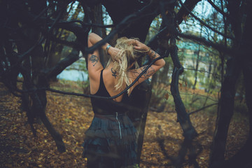 young beautiful woman in a cold autumn near a tree
