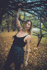 young beautiful woman in a cold autumn near a tree