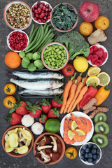 Healthy food for good health concept with super food of sardines, crevettes, fruit, vegetables, herbs and spice. Foods very high in antioxidants, anthocyanins, omega 3 fatty acids, fibre and vitamins.