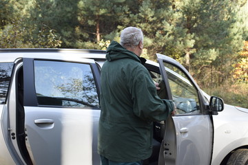 пожилой мужчина стоит рядом с машиной   © sashasandro