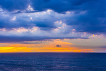 Naklejka na ściany i meble Sea sunset of amazing beauty. Relaxing view of blue clouds over orange yellow sunlight. Balangan beach view, Jimbaran, South Kuta, Bali, Indonesia.