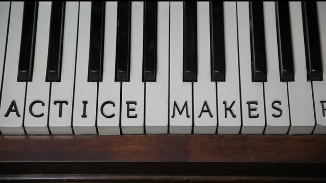 PRACTICE MAKES PERFECT written on white piano keys