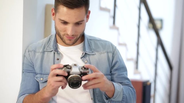 Man at home using vintage reflex camera
