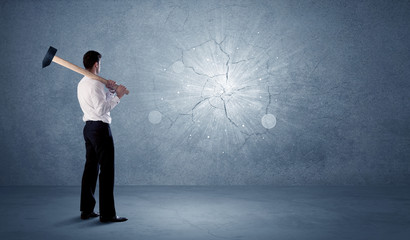 Business man hitting wall with a hammer