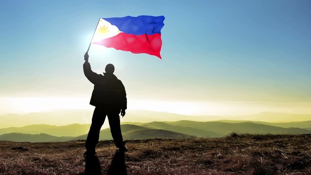 Successful silhouette man winner waving Philippines flag on top of the mountain peak, Cinemagraph LOOP background