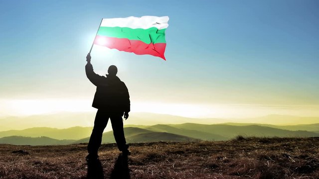 Successful silhouette man winner waving Bulgarian flag on top of the mountain peak. Cinemagraph LOOP background