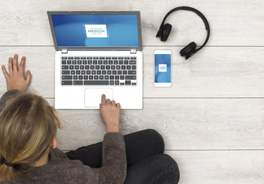 User Sitting on Floor with Laptop, Smartphone and Headphones Mockup