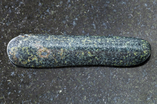 tumbled tholeiite basalt stone on dark