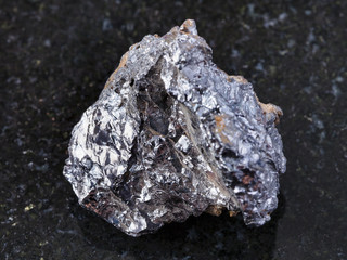 raw ilmenorutile (Nb-bearing rutile) stone on dark
