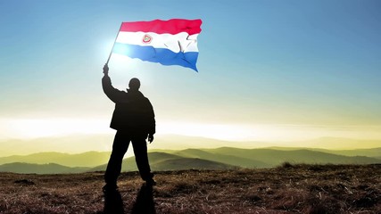 Successful silhouette man winner waving Paraguay flag on top of the mountain peak, Cinemagraph LOOP background