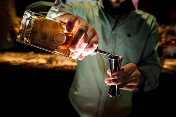 Bartender pouring a syrup for making a cocktail