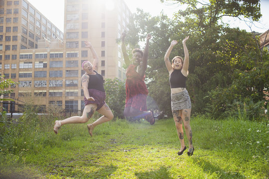 Happy friends jumping in the park