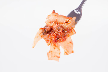 Pappardelle with bolognese sauce on a fork on a white background