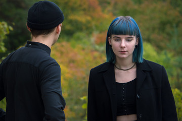 Gothic couple love story. Man and blue hair girl at black clothes at green river background