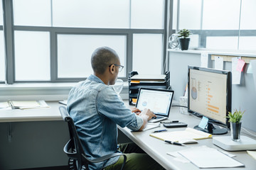 Black businessman using laptop in office