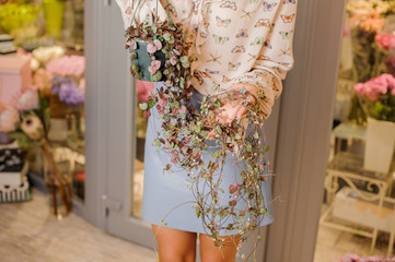 Woman in stylish skirt and shirt holding a pot with flower