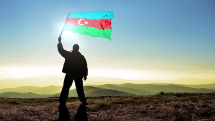 Successful silhouette man winner waving Azerbaijan flag on top of the mountain peak. Cinemagraph LOOP background
