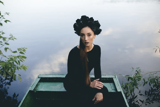 Portrait Of Woman Wearing Black Dress In Boat On Lake
