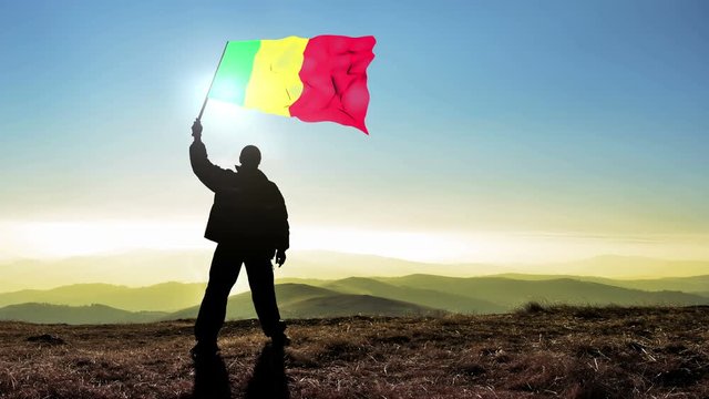Successful silhouette man winner waving Mali flag on top of the mountain peak, Cinemagraph LOOP background