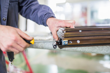 Factory for aluminum and PVC windows and doors production. Manual worker assembling PVC doors and windows. 