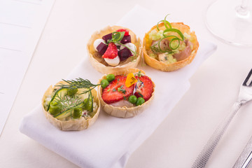 Tartlet with goat cheese and baked beet, with strawberry and a comb, a whitefish with mayonnaise and egg, a crab, shrimps and apple